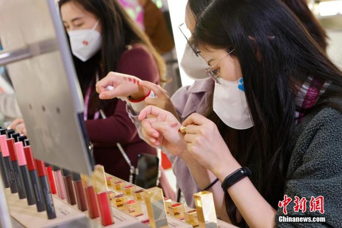 圖為女生正在體驗口紅產(chǎn)品。 殷立勤 攝