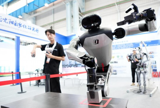 9月5日，在沈陽的2025全球工業(yè)互聯(lián)網(wǎng)大會的展覽區(qū)現(xiàn)場，中國科學(xué)院沈陽自動化研究所的機器人工程師在調(diào)試具身智能操作系統(tǒng)。新華社記者 李鋼 攝