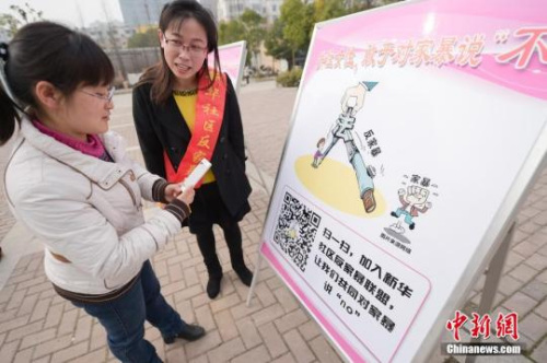 資料圖：今年3月8日，安徽合肥新華社區(qū)志愿者夏一瓊(右)向市民普及反家暴相關(guān)法律知識(shí)。鐘欣 攝